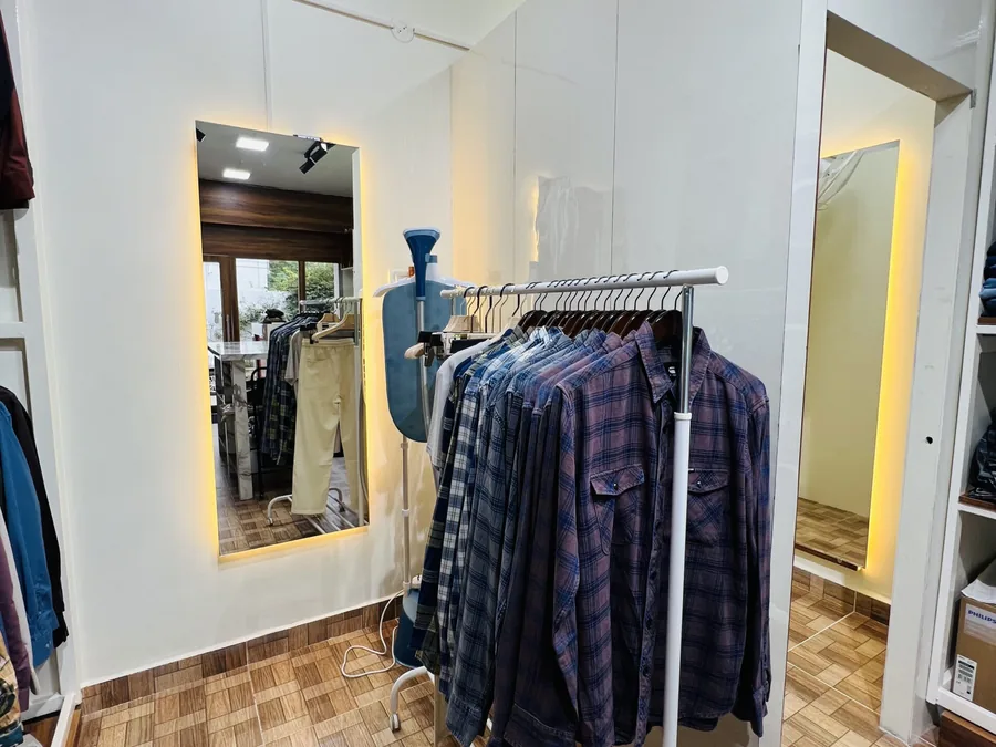Fitting area and curated clothing racks at D Iconique